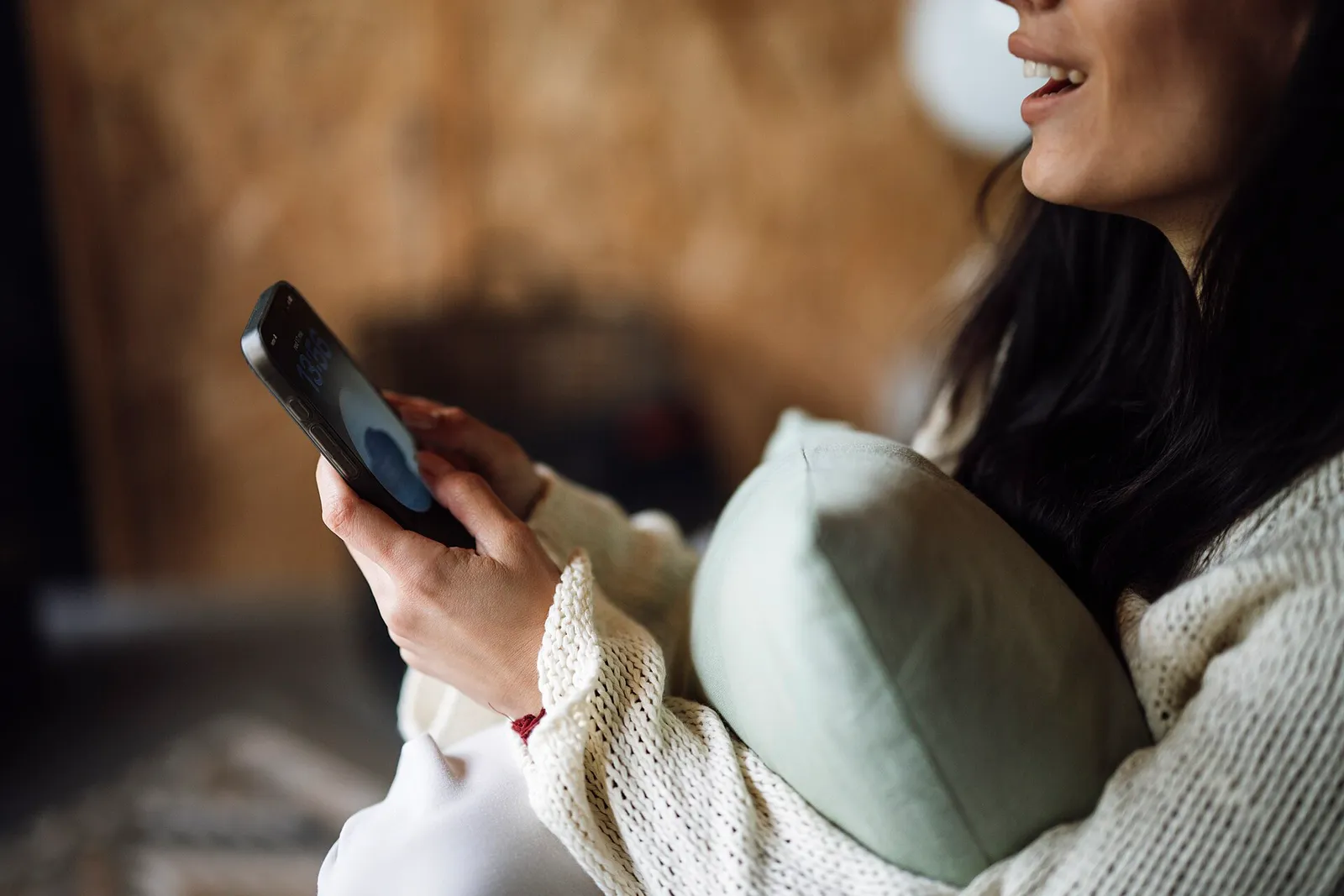 Eine Frau nutzt zu Hause ihr Smartphone (Symbolbild)