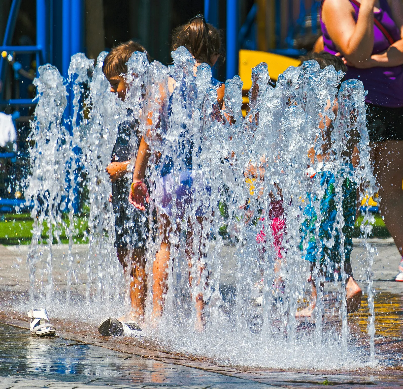 Menschen kühlen sich an einem Brunnen ab (Symbolbild)