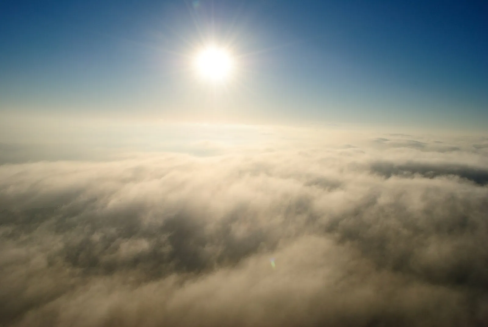 Gleißende Sonne über Wolken (Symbolbild)