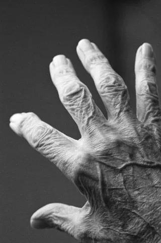 Eine Pflegekraft hält die Hand einer älteren Person
