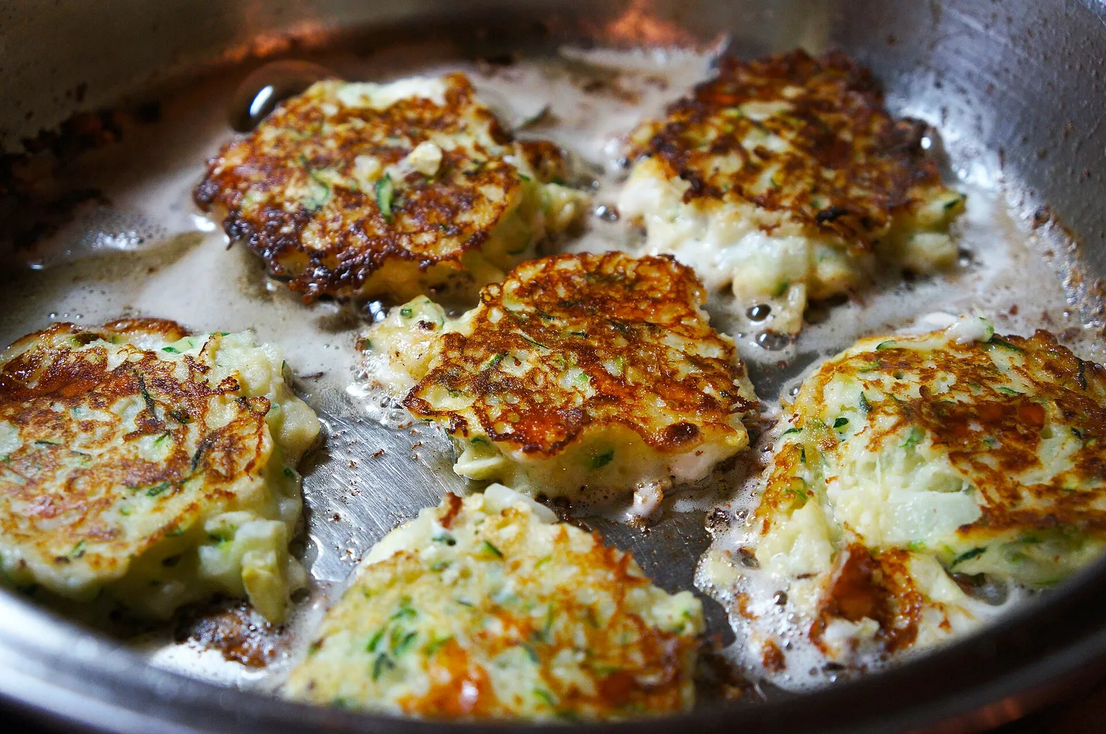 Goldbraun gebratene Zucchinipuffer auf einem Teller (Symbolbild)