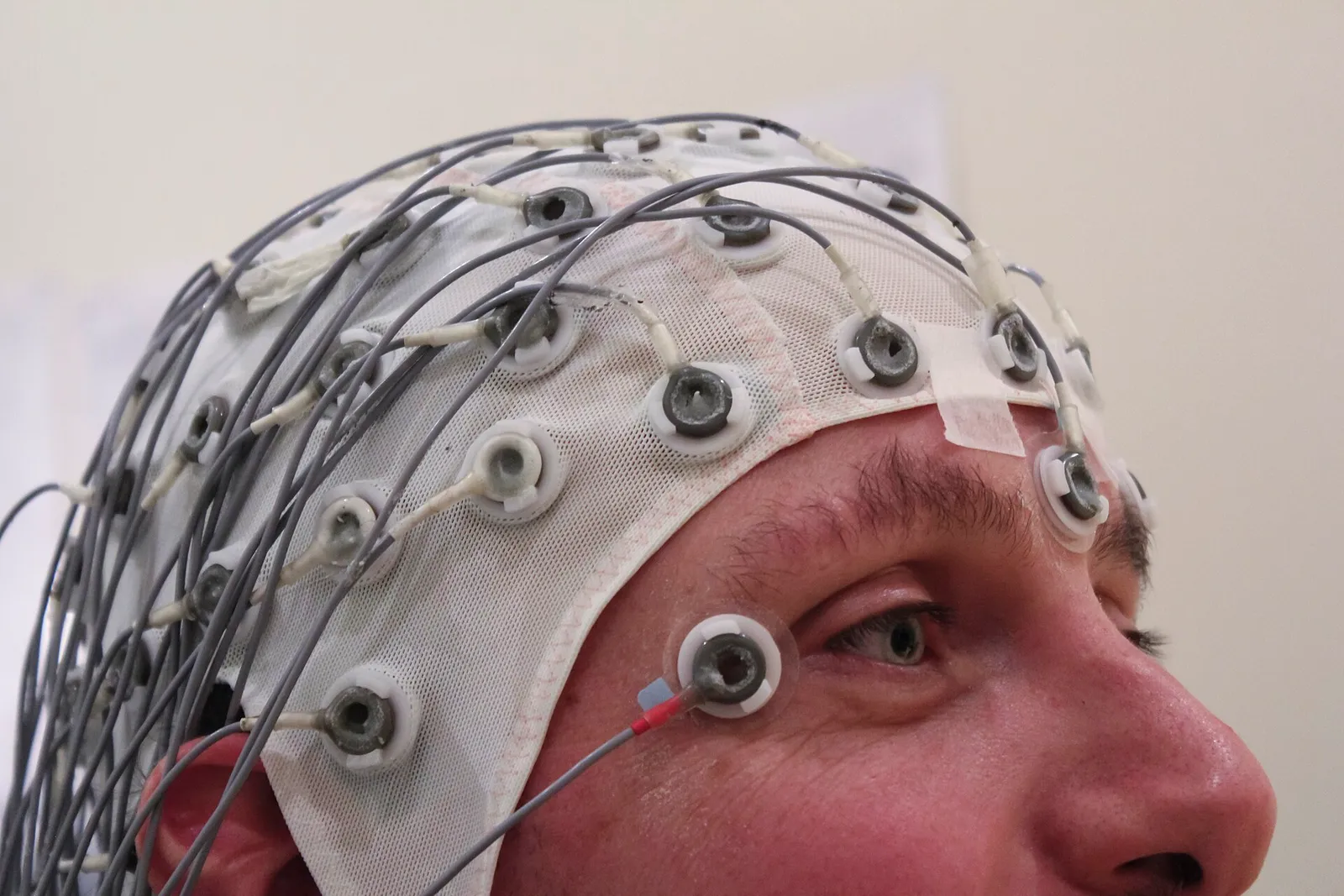 Eine Person trägt eine Haube mit EEG-Elektroden