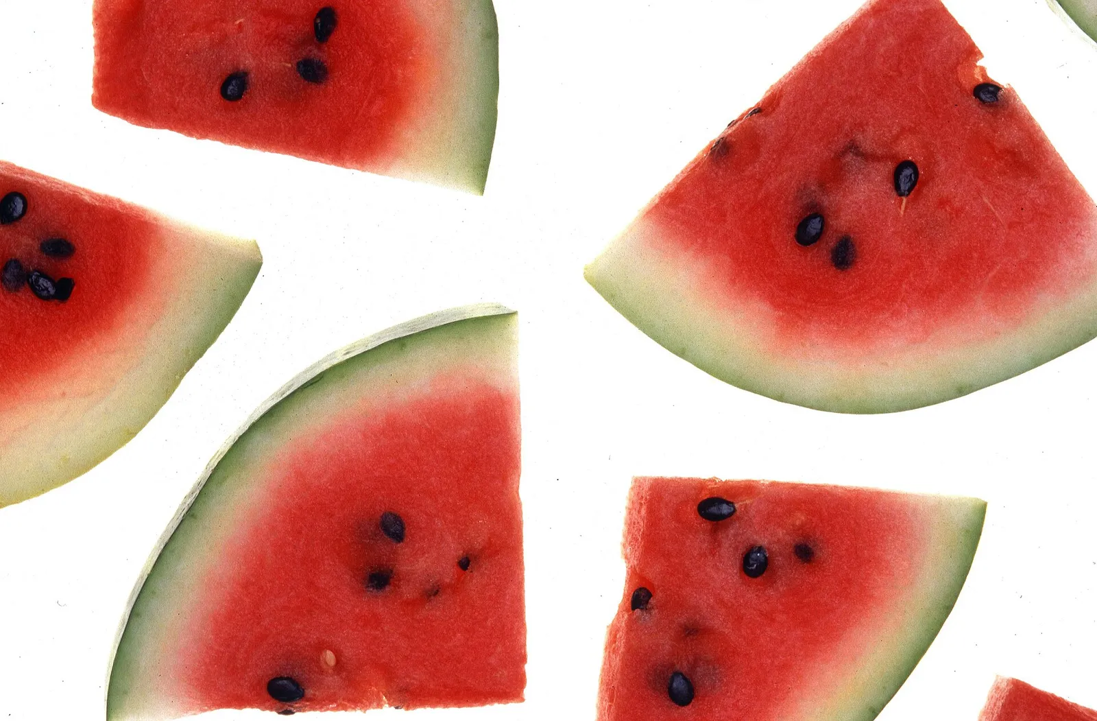 Aufgeschnittene Wassermelone mit rotem Fruchtfleisch, heller Schicht und grüner Rinde